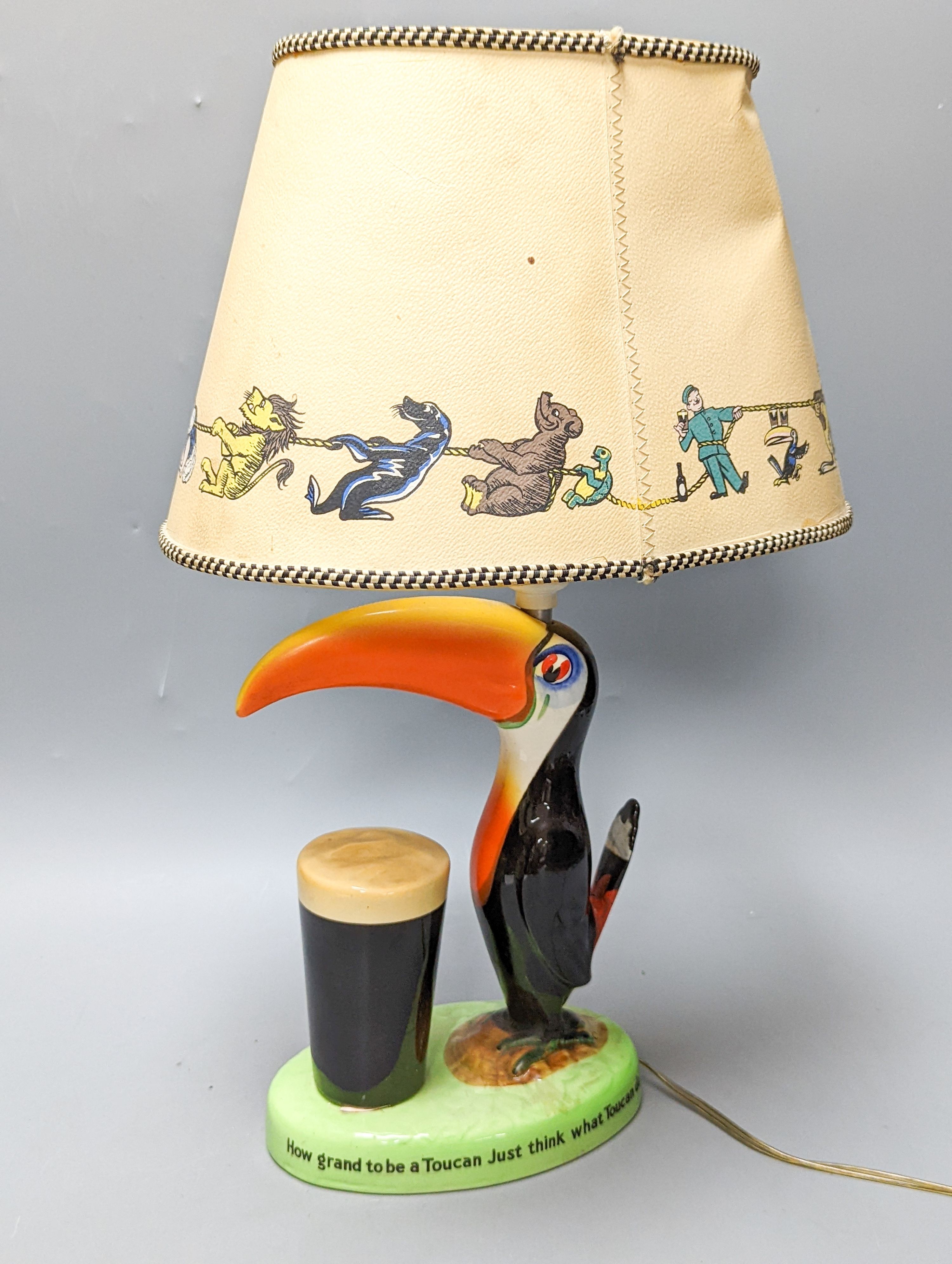 A Guinness toucan lamp, with original shade, tail repaired